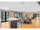 Open-concept dining area featuring hardwood floors, a stylish chandelier, and brick walls, adjacent to the kitchen at 1002 S Frankland Rd, Tampa, FL 33629