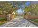 Long driveway leading to a white home with brick pillars and mature trees providing shade and curb appeal at 1002 S Frankland Rd, Tampa, FL 33629