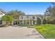 Stately two-story home with a circular porch, lush landscaping, and a paved driveway at 1002 S Frankland Rd, Tampa, FL 33629