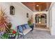 Inviting covered front porch with a bench, potted plants, lantern sconces, and a glimpse of the home's interior at 1002 S Frankland Rd, Tampa, FL 33629