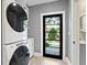 Bright laundry room featuring a stacked washer and dryer and access to the backyard at 1002 S Frankland Rd, Tampa, FL 33629