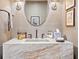 Stylish powder room with a marble countertop, elegant lighting, and neutral decor at 1002 S Frankland Rd, Tampa, FL 33629