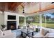 Well-lit sunroom has a fireplace, ceiling fans, and comfortable seating with backyard views at 1002 S Frankland Rd, Tampa, FL 33629
