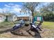 Backyard with a fire pit, chairs, and patio in the distance at 1012 W Berry Ave, Tampa, FL 33603