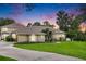 Charming single-story home featuring a well-manicured lawn and inviting curb appeal under a colorful sunset sky at 11505 Heron Hills Ln, Riverview, FL 33569