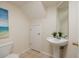 Cozy bathroom with pedestal sink, ceramic tile flooring, and modern fixtures creating an efficient and serene space at 122 Coquina Bay Dr, St Petersburg, FL 33705