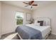 Well-lit bedroom features a ceiling fan, large window with blinds, and plush carpeting at 122 Coquina Bay Dr, St Petersburg, FL 33705