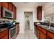 Traditional kitchen with wood cabinetry, granite countertops, stainless steel appliances, and tile flooring at 122 Coquina Bay Dr, St Petersburg, FL 33705