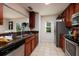 Traditional kitchen featuring wood cabinetry, stainless appliances, granite countertops, and access to the outdoor patio at 122 Coquina Bay Dr, St Petersburg, FL 33705