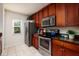 Kitchen features wood cabinets, stainless steel appliances, granite countertops, and tile flooring at 122 Coquina Bay Dr, St Petersburg, FL 33705