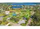 Aerial view of the local park with tennis courts, playground, open space and a picturesque lake beyond at 130 81St Ne Ave, St Petersburg, FL 33701
