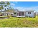 Exterior view of the house showing its light blue color, carport, and enclosed front porch at 130 81St Ne Ave, St Petersburg, FL 33701