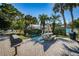 Relaxing community space with outdoor grill, picnic table, and mature palm trees at 1308 Pine Ridge E Cir # E3, Tarpon Springs, FL 34688