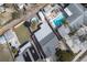 Aerial view of a home with a well-maintained roof, fenced-in backyard, and in-ground and above ground pools at 1413 Wisconsin Ave, Palm Harbor, FL 34683