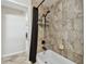 Bathroom area featuring a tiled tub with a dark shower curtain, a shower head, and wall-mounted storage at 14171 80Th Ave, Seminole, FL 33776