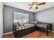 Bedroom featuring wood flooring, two twin beds with bedding, a ceiling fan, and a window at 14171 80Th Ave, Seminole, FL 33776