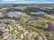 Serene aerial view showcasing homes nestled amidst picturesque lakes and verdant woodlands at 15701 Greyrock Dr, Spring Hill, FL 34610