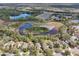 Aerial view of homes in a community located next to a serene lake and wooded landscape at 15701 Greyrock Dr, Spring Hill, FL 34610