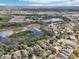 Aerial view of a community featuring homes near a scenic lake and natural surroundings at 15701 Greyrock Dr, Spring Hill, FL 34610