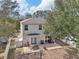 Aerial view of backyard with outdoor dining set on a stone patio and white picket fence at 15701 Greyrock Dr, Spring Hill, FL 34610