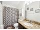 Cozy bathroom with granite counters, tiled floors, and patterned shower curtain for a fresh, updated look at 15701 Greyrock Dr, Spring Hill, FL 34610
