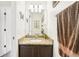 Bathroom featuring a granite countertop, dark wood cabinets, decorative mirror, and modern lighting at 15701 Greyrock Dr, Spring Hill, FL 34610