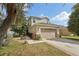 Charming two-story home featuring a tan exterior, stone accents, and an attached two-car garage at 15701 Greyrock Dr, Spring Hill, FL 34610