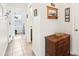 Hallway with tile flooring, a wooden cabinet, and views into the laundry room and other rooms at 15701 Greyrock Dr, Spring Hill, FL 34610