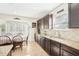 Well-lit kitchen featuring stainless steel appliances, granite countertops, dark wood cabinets, and tile flooring at 15701 Greyrock Dr, Spring Hill, FL 34610