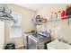 Well-lit laundry room features front load washer and dryer, folding counter, and ample storage shelves at 15701 Greyrock Dr, Spring Hill, FL 34610