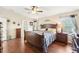 Bright and airy main bedroom with a large window, wood floors, ceiling fan and ensuite bathroom access at 15701 Greyrock Dr, Spring Hill, FL 34610