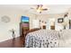 Spacious main bedroom with ensuite bathroom access, television, wood floors, and a ceiling fan at 15701 Greyrock Dr, Spring Hill, FL 34610