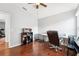 Bright office features wood floors, white walls, ceiling fan, desk, shelves and large windows for plenty of natural light at 15701 Greyrock Dr, Spring Hill, FL 34610