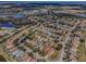 Aerial view of a residential neighborhood with homes, trees, lakes, and a school at 19609 Timberbluff Dr, Land O Lakes, FL 34638