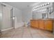 Well-lit bathroom featuring tiled floors, a shower stall, soaking tub, double vanity, and large mirror at 19609 Timberbluff Dr, Land O Lakes, FL 34638