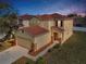 Two-story home with a red tile roof, neutral stucco, stone accents, and a two-car garage at 19609 Timberbluff Dr, Land O Lakes, FL 34638