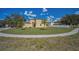 Spacious front yard with grass, small palm trees, and walkway to the front entrance at 19609 Timberbluff Dr, Land O Lakes, FL 34638