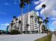 Stunning exterior view of the high rise condo with many palm trees and blue skies at 2401 Bayshore Blvd # 101, Tampa, FL 33629