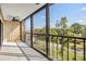 Enclosed balcony with black metal railing and wooded view at 2700 Cove Cay Dr # 4-B, Clearwater, FL 33760