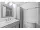 Bright bathroom featuring a single sink vanity, large mirror, storage cabinet, and a toilet at 2700 Cove Cay Dr # 4-B, Clearwater, FL 33760