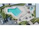 Aerial view of a beautiful pool, lounge chairs and tropical umbrellas at 2700 Cove Cay Dr # 4-B, Clearwater, FL 33760