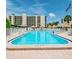 Large Community Pool with lounge chairs and shady umbrellas at 2700 Cove Cay Dr # 4-B, Clearwater, FL 33760