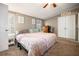 Cozy bedroom featuring a large bed with a patterned quilt and a ceiling fan at 3307 Fox Ridge Blvd, Wesley Chapel, FL 33543
