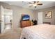Bedroom featuring a ceiling fan, television, a desk, and a view to the house entrance at 3307 Fox Ridge Blvd, Wesley Chapel, FL 33543