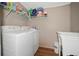 Laundry room features a washer and dryer, shelving for storage and a utility sink at 3307 Fox Ridge Blvd, Wesley Chapel, FL 33543