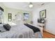 Bright bedroom featuring hardwood floors, a ceiling fan, and a dresser with mirror at 349 Shirley Ave, Belleair, FL 33756