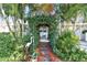 Lush walkway to the front door, featuring decorative plants and a charming archway at 349 Shirley Ave, Belleair, FL 33756