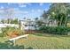 Charming front yard with tropical landscaping, green lawn, and a bench for enjoying the outdoors at 349 Shirley Ave, Belleair, FL 33756