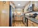 Functional kitchen featuring stainless steel appliances, wood cabinets, and attractive countertops at 349 Shirley Ave, Belleair, FL 33756