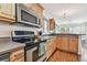 Modern kitchen equipped with stainless steel appliances, wood cabinets, and granite countertops at 349 Shirley Ave, Belleair, FL 33756